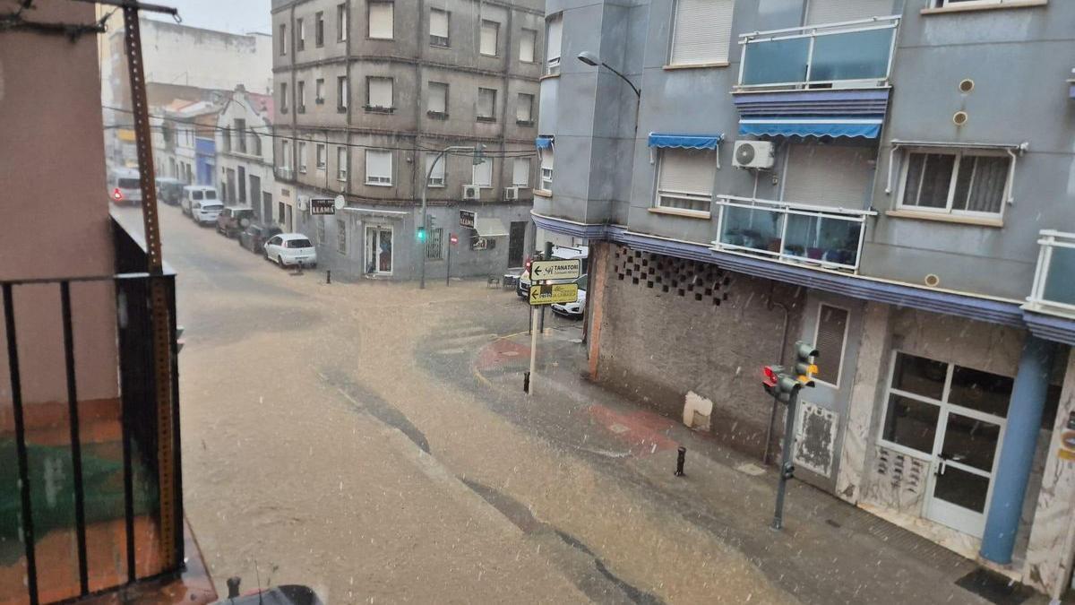 Una calle de Oliva, con mucha agua, tras las intensas precipitaciones.