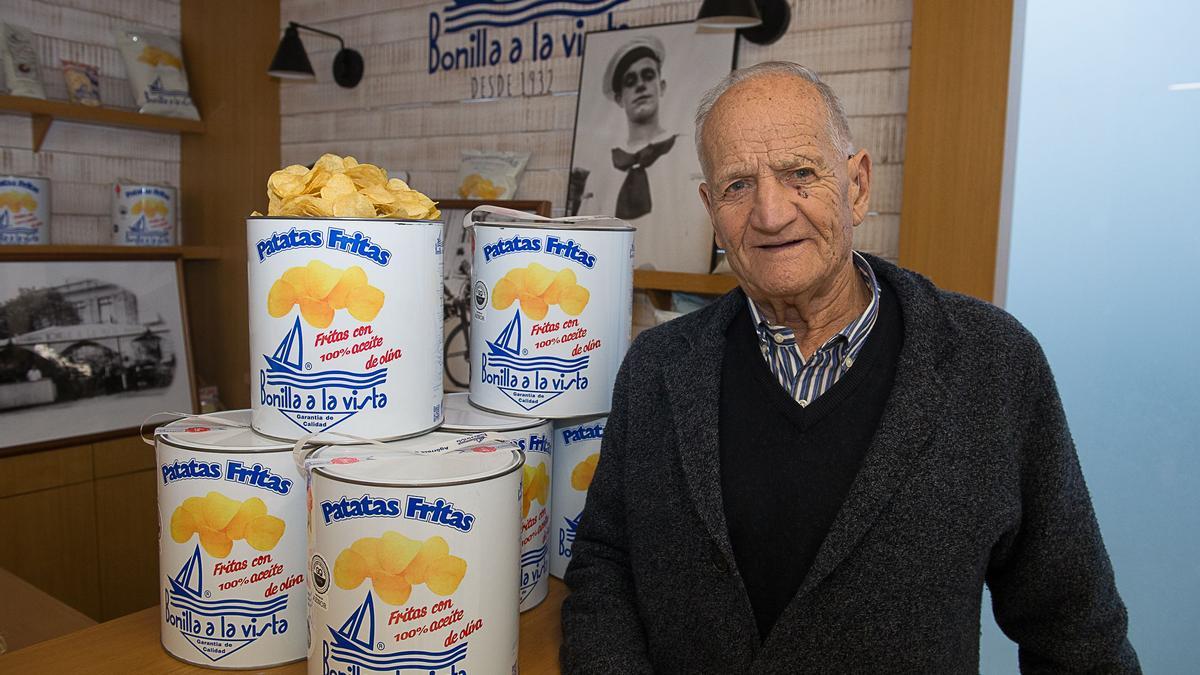 César Bonilla junto a varias latas de patatas fritas de la firma Bonilla a la vista