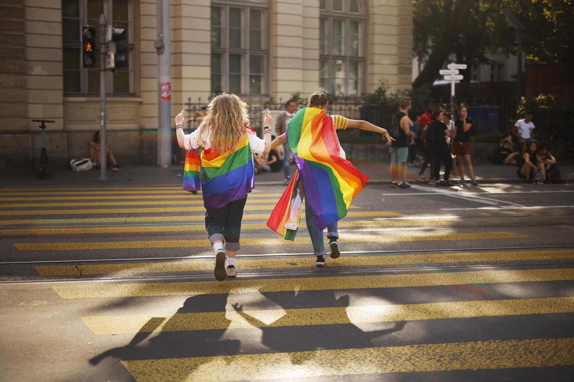 Dos manifestantes portan banderas LGBTI en Zúrich