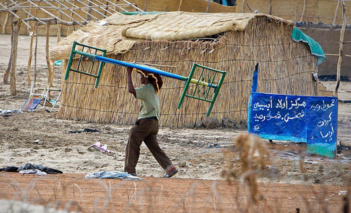 Fotografia facilitada per la Missió de l’ONU al Sudan (UNMIS) que mostra un home emportant-se un llit després d’un saqueig en una vivenda a Abyei, a l’homònima regió sudanesa. La UNMIS ha condemnat aquest dilluns els incendis i saquejos en aquesta àrea a mans d’individus armats.