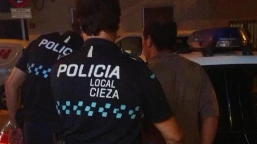 Dos agentes de la Policía Local custodian al detenido.