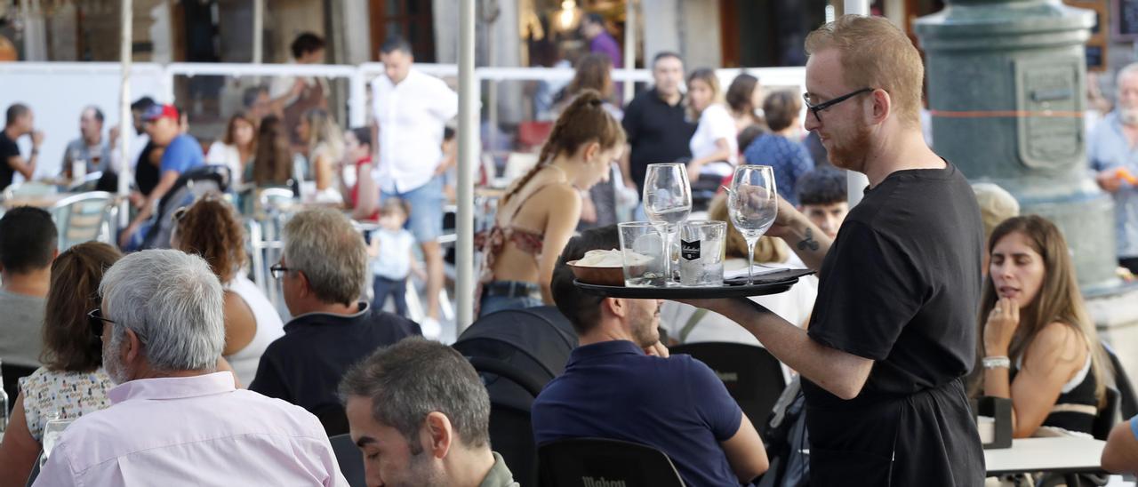 Un camarero atendiendo a clientes en una terraza de Vigo.