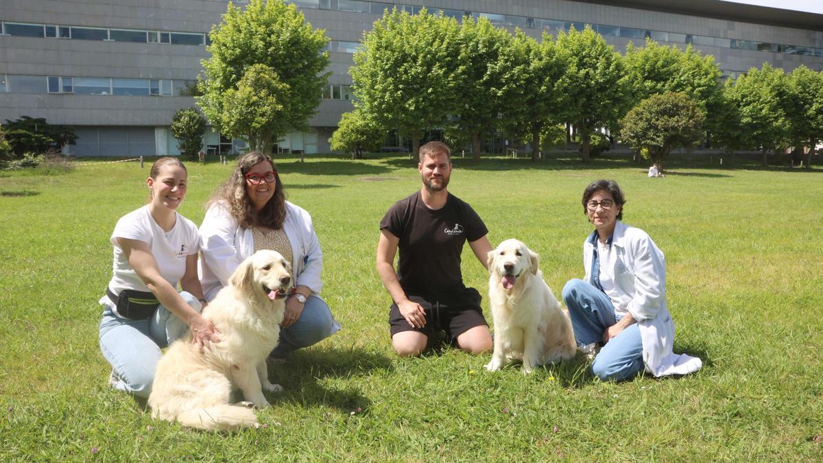 De izqda. a dcha., Lucía Lombardía (adiestradora canina de la Escuela Candamín, y monitora de la actividad); Lara Leyva (TCAE de enfermería); Adrián Paredes (adiestrador de Candamín, y monitor); y Estrella Vázquez (TCAE), con dos perros de terapia, en el jardín del Hospital de Oza.
