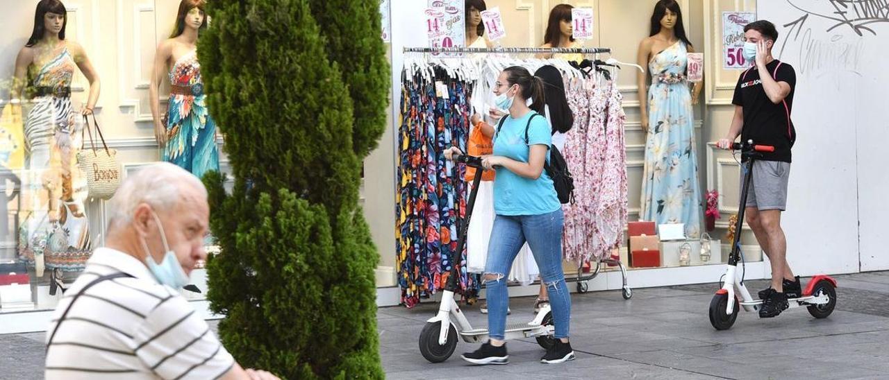 Dos jóvenes con patinete eléctrico, en el centro de Córdoba.