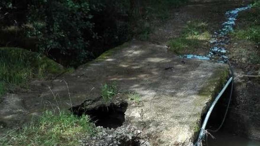 El puente de piedra derruido que ha aislado desde diciembre a parte de las fincas del pueblo de Sisiello, en Serín.