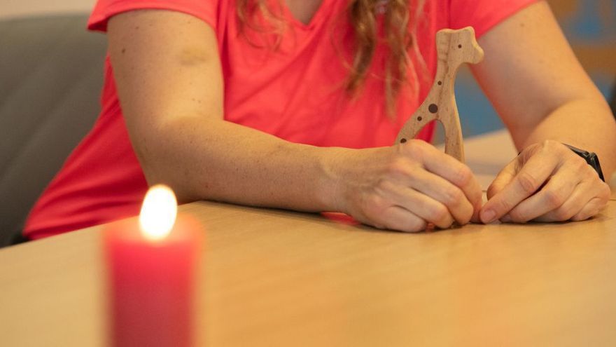 Una de las madres sostiene una jirafa de madera que tenía preparada para su bebé.