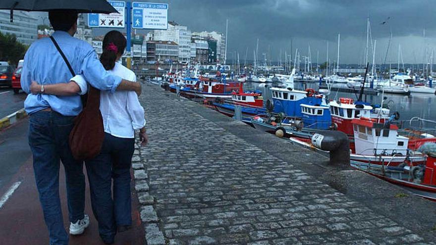 Una pareja pasea por la dársena de A Coruña. / carlos pardellas