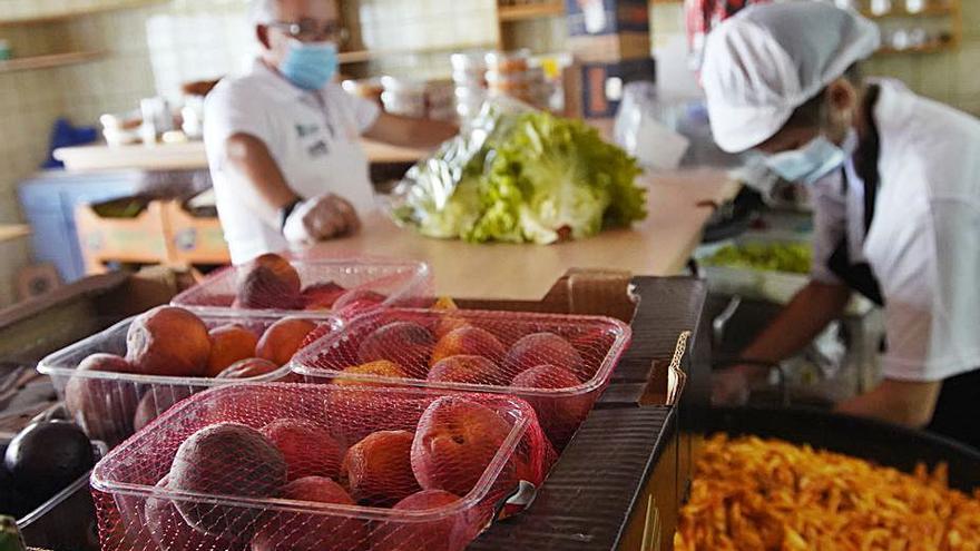 Dos trabajadores de la cocina solidaria preparan los menús. | J. L. Fernández