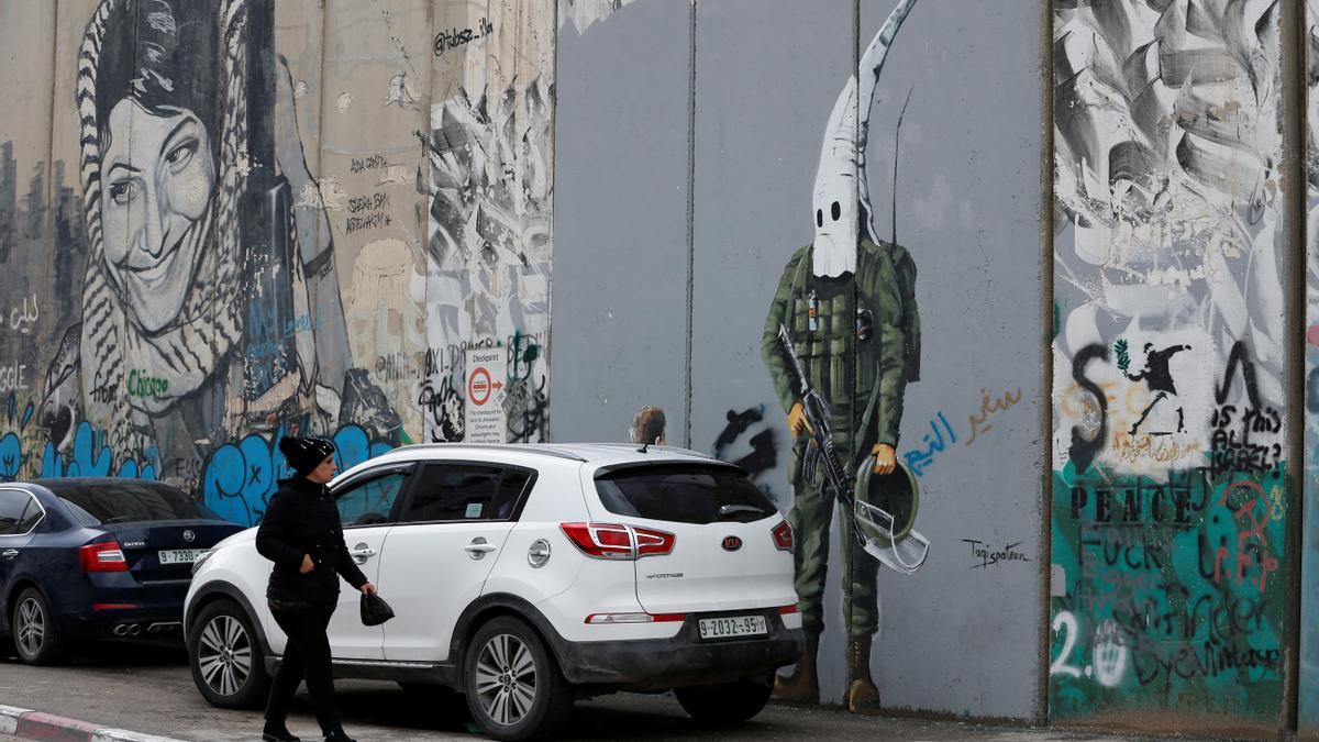 Una mujer palestina mira un grafiti pintado en el muro levantado por Israel en Belén, en la Cisjordania ocupada.