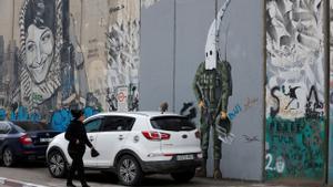 Una mujer palestina mira un grafiti pintado en el muro levantado por Israel en Belén, en la Cisjordania ocupada.