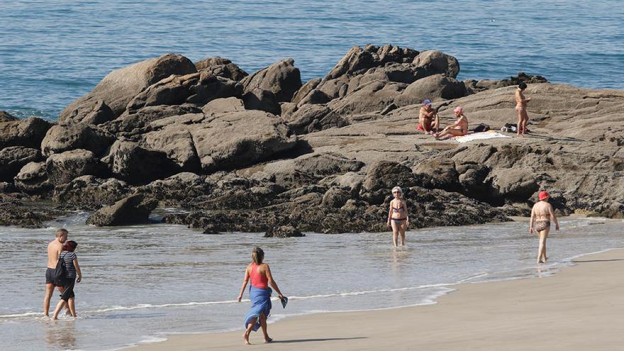 Los primeros bañistas del año disfrutando en Samil del sol // Alba Villar