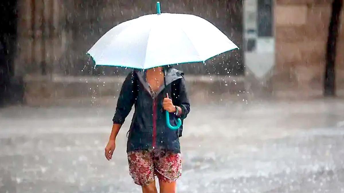 Una viandante se protege con un paraguas de la lluvia.