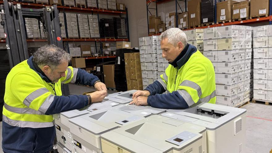 Arriba, dos empleados de Digalco en el almacén. Abajo, una serie de ordenadores de la empresa coruñesa.