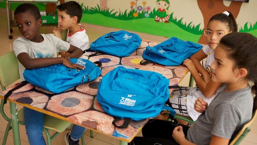 Niños el primer día de colegio con el material escolar facilitado por La Caixa.