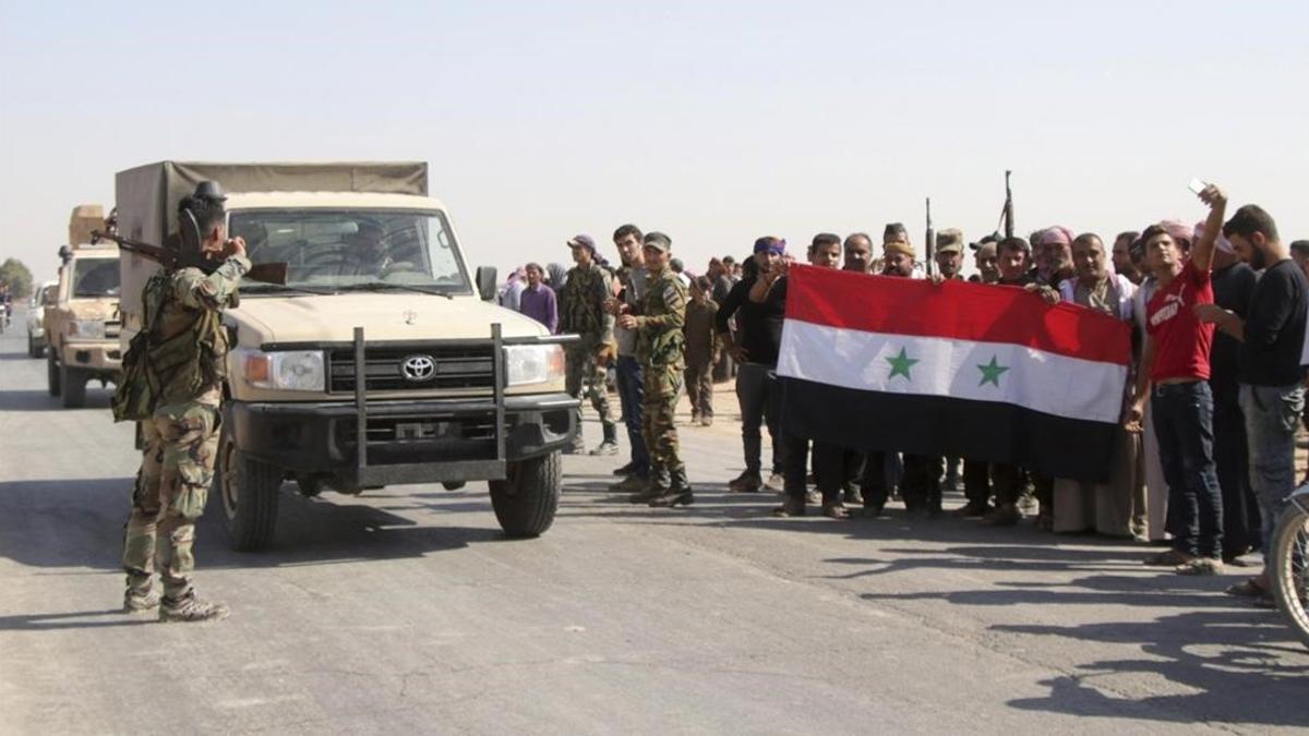Vecinos de la aldea de Ghebesh dan la bienvenida a las tropas sirias.