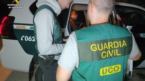 Dos agentes de la Guardia Civil de la UCO junto a Karim E.B en un vehículo del cuerpo, a su llegada a la comandancia de la Guardia Civil de Barbate.