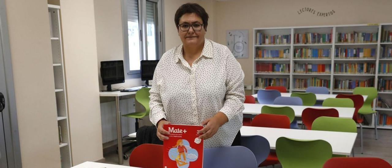La presidenta de FOANPAS, Iria Salvande, posa con los libros de texto de sus hijos para este curso en el CEIP Seis do Nadal.