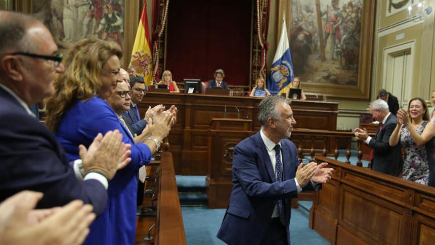 Los miembros anterior gobierno liderado por Coalición Canaria aplauden al socialista Ángel Víctor Torres (c), tras ser elegido presidente de Canarias al finalizar el debate del pleno de investidura.