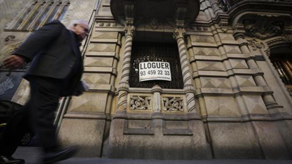 Un portal de la calle de València, con un cartel de piso en alquiler.