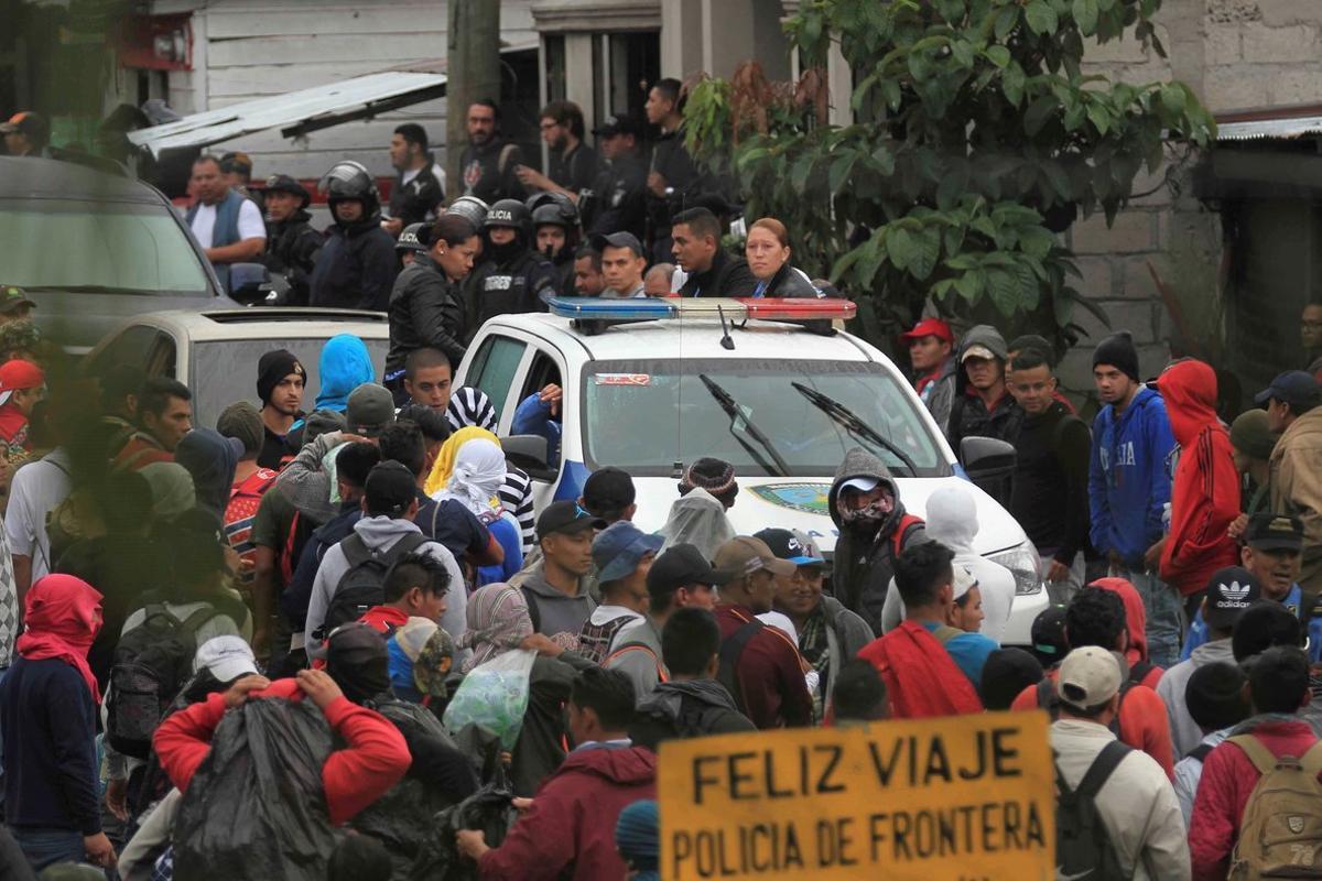 Migrantes hondurenos hacen fila en un control policial donde se les verifica sus antecedentes penales y si tienen alguna orden de captura  y que los ninos acompanados por sus padres lleven su documentacion en regla para poder continuar su paso en la aduana de Agua Caliente .  EFE Gustavo Amador