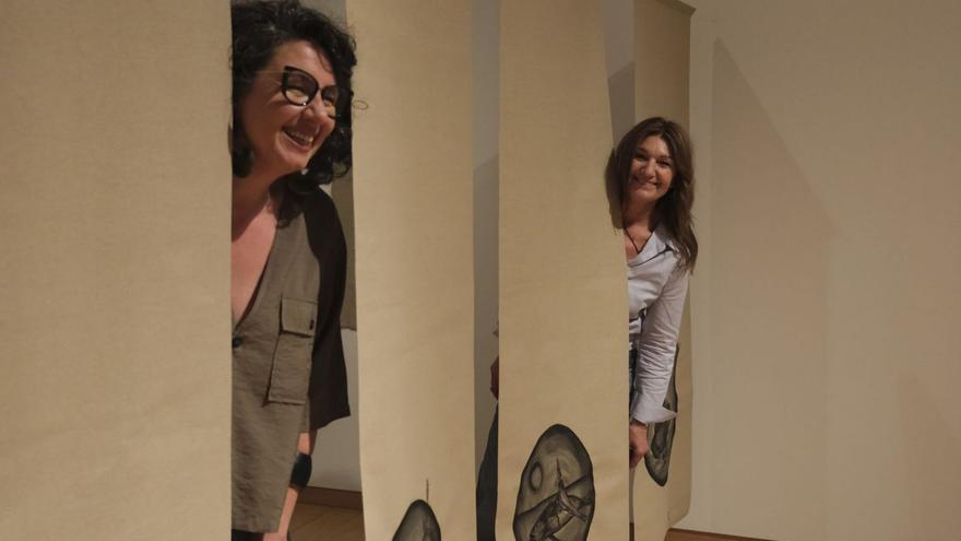 Raquel (derecha), con Marta, comisaria de la exposición entre las telas flotantes.