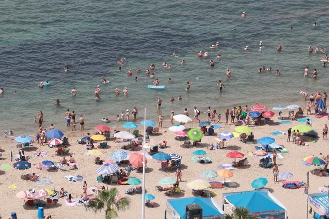 Baños, helados, agua fría… turistas y vecinos combaten la ola de calor en Benidorm