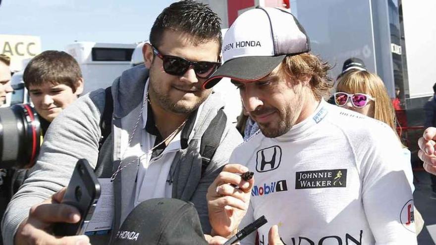 Fernando Alonso firma autógrafos.