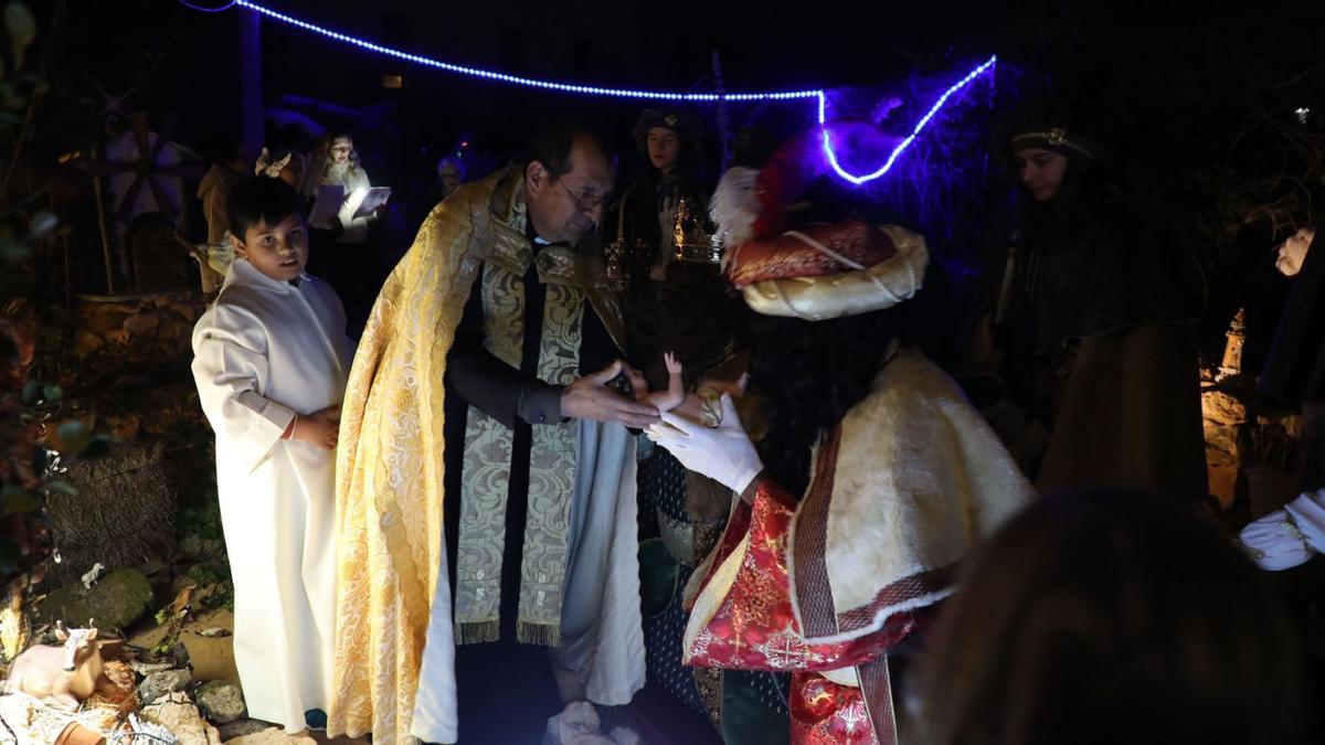 El párroco de Sant Ferran ofrece la imagen del Niño Jesús a los Reyes Magos. 