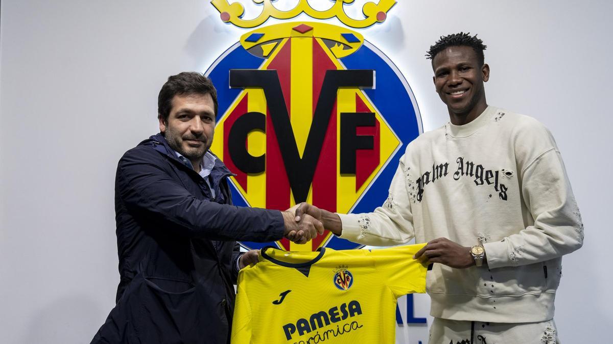 Yerson Mosquera (d), con la camiseta del Villarreal CF junto al consejero delegado del club, Roig Negueroles.