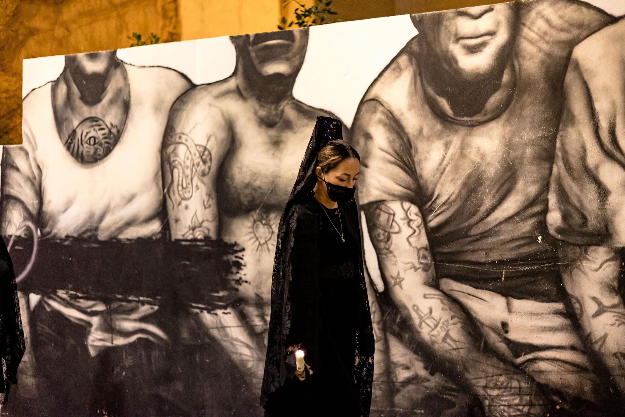 14/11/2021. Una «manola» en la procesión de la patrona de Benidorm pasa junto a un muro del Carrer Major grafiteado por el artista HUNTER.87 de La Vila Joiosa.