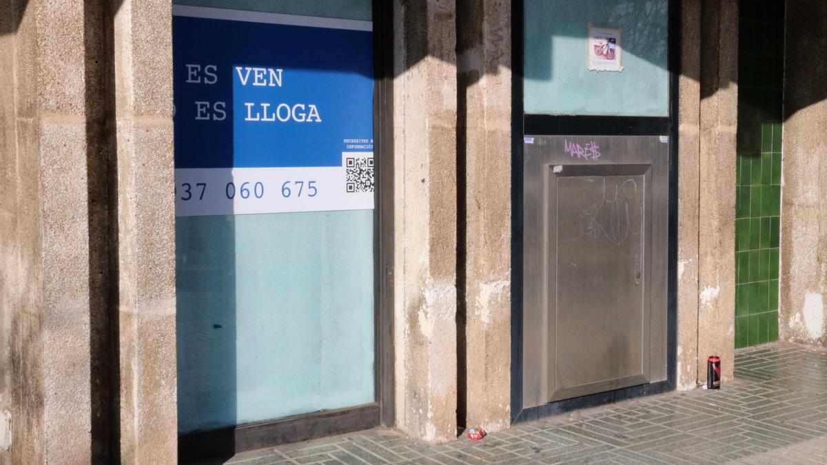 El lateral d&#039;una antiga entitat bancària a Segur de Calafell, actualment tancada i amb un cartell de venda o lloguer