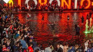 WTX25. TORONTO (CANADA), 14/06/2019.- Aficionados de los Raptors de Toronto celebran la victoria de su equipo en el Ayuntamiento de Toronto, Canadá, este jueves 13. Los Raptors de Toronto, favorecidos con las bajas del alero Kevin Durant y del escolta Klay Thompson, derrotaron a domicilio esta noche por 110-114 a los Warriors de Golden State en el sexto partido de las Finales de la NBA que ganaron por 4-2 al mejor de siete. EFE/ Warren Toda