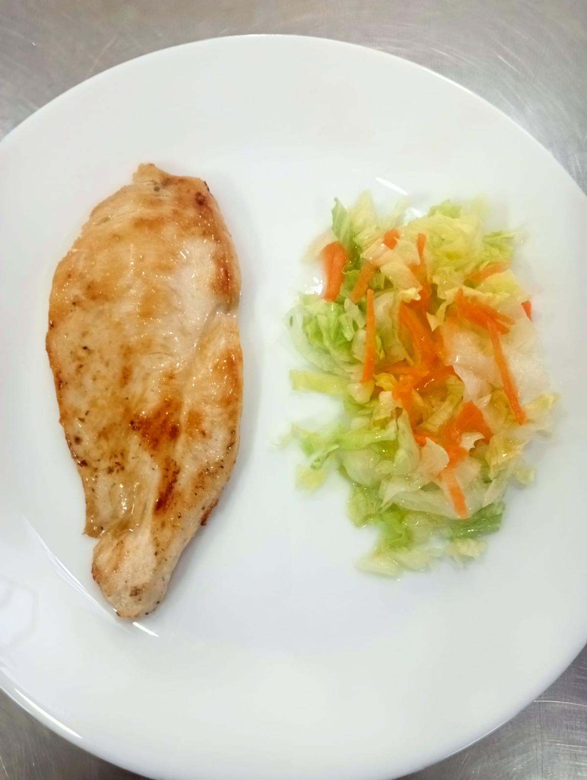 Pollo a la plancha con ensadala de guarnición.