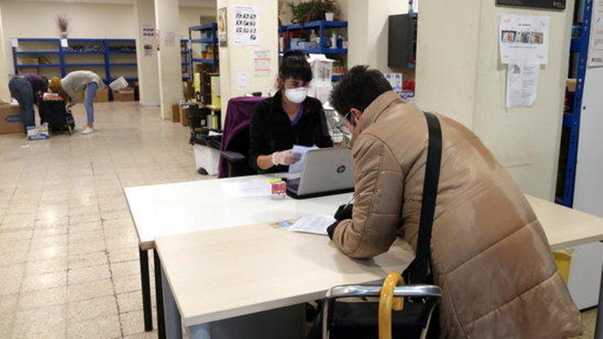 Una usuària del centre de distribució d&#039;aliments de Girona recollint els seus lots