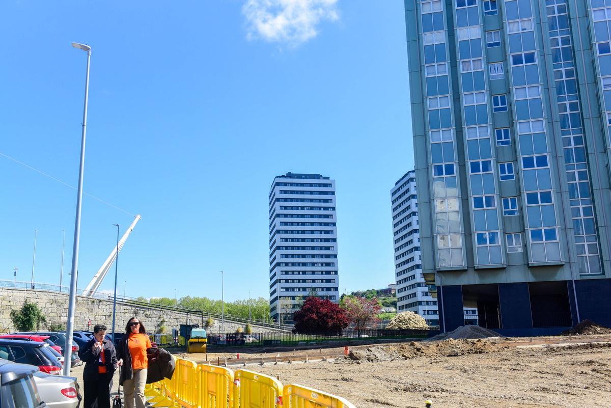 Obras de urbanización en Someso, con torres de viviendas de fondo.