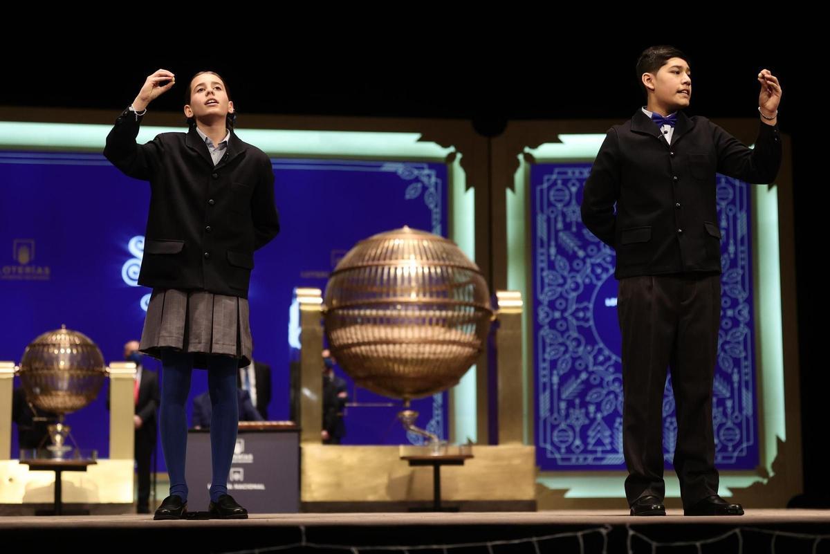 Dos de los niños de la residencia de San Ildefonso cantan uno de los quintos premios al número 70.316, durante la celebración del Sorteo 