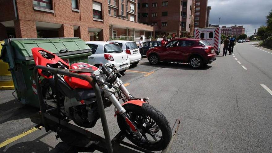 La motocicleta accidentada con la uvi móvil al fondo.