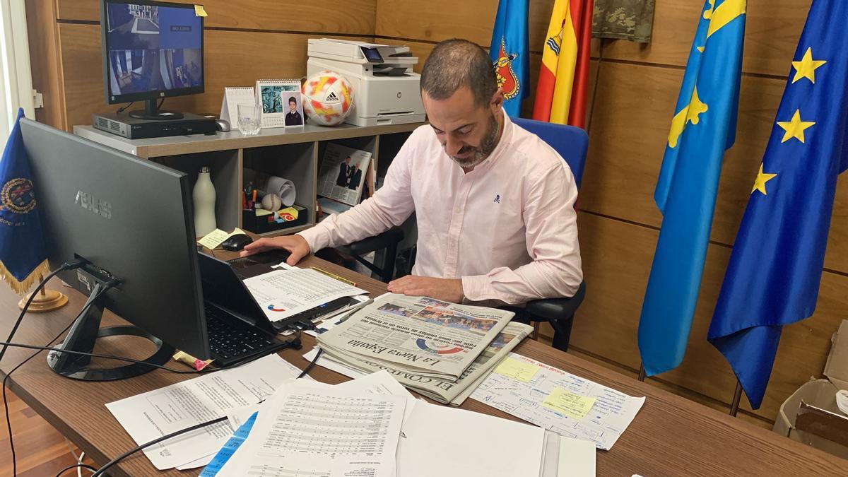 Ángel García, en su despacho, mirando la portada de LA NUEVA ESPAÑA de este lunes 29 de mayo.