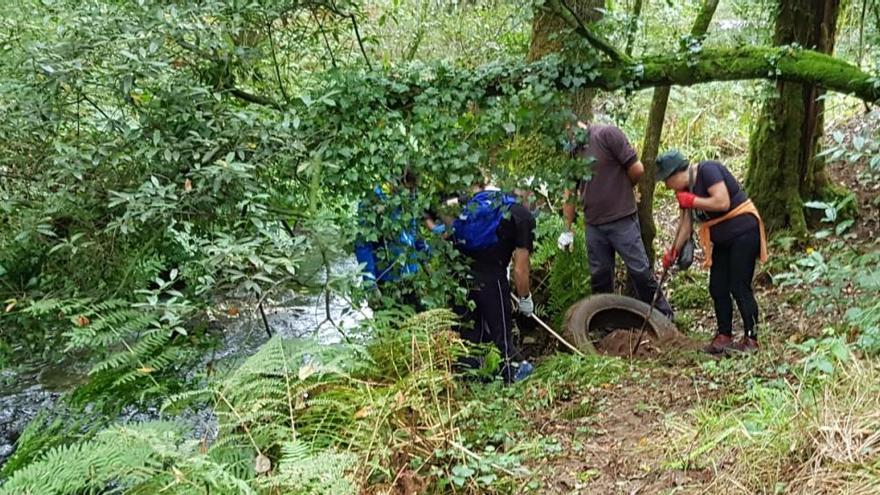 Participantes en la limpieza del entorno fluvial del río Vea organizada por A Xesteira, esta mañana, en Couso. // A Xesteira