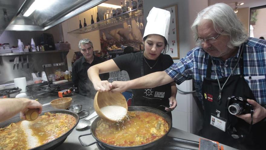 Un grupo de turistas aprende a cocinar una paella en Valencia.