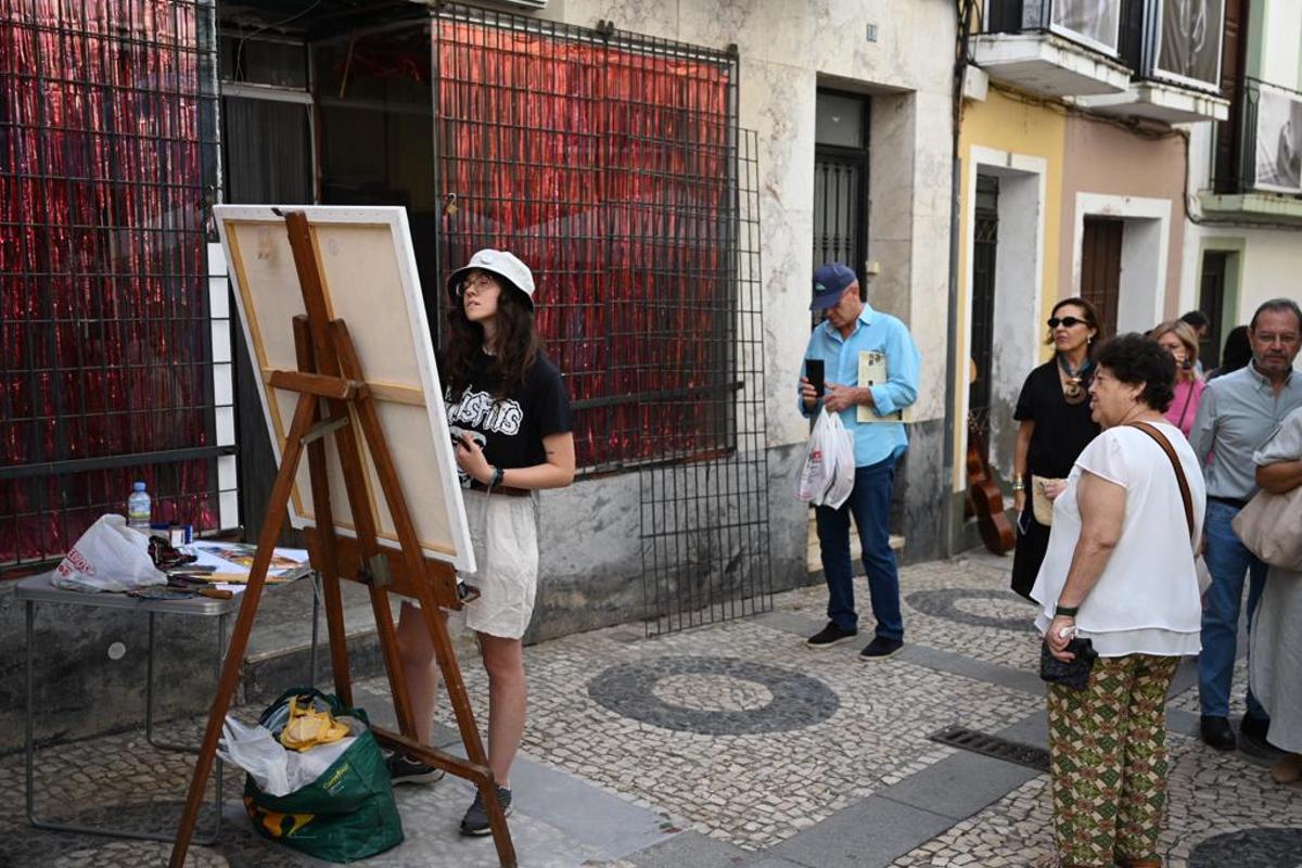 Elena Vargas pintando ante la atenta mirada de los curiosos.