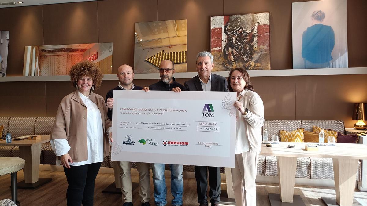 Encarni Navarro, la secretaria de AIOM y los empresarios malagueños posan ante el cheque solidario