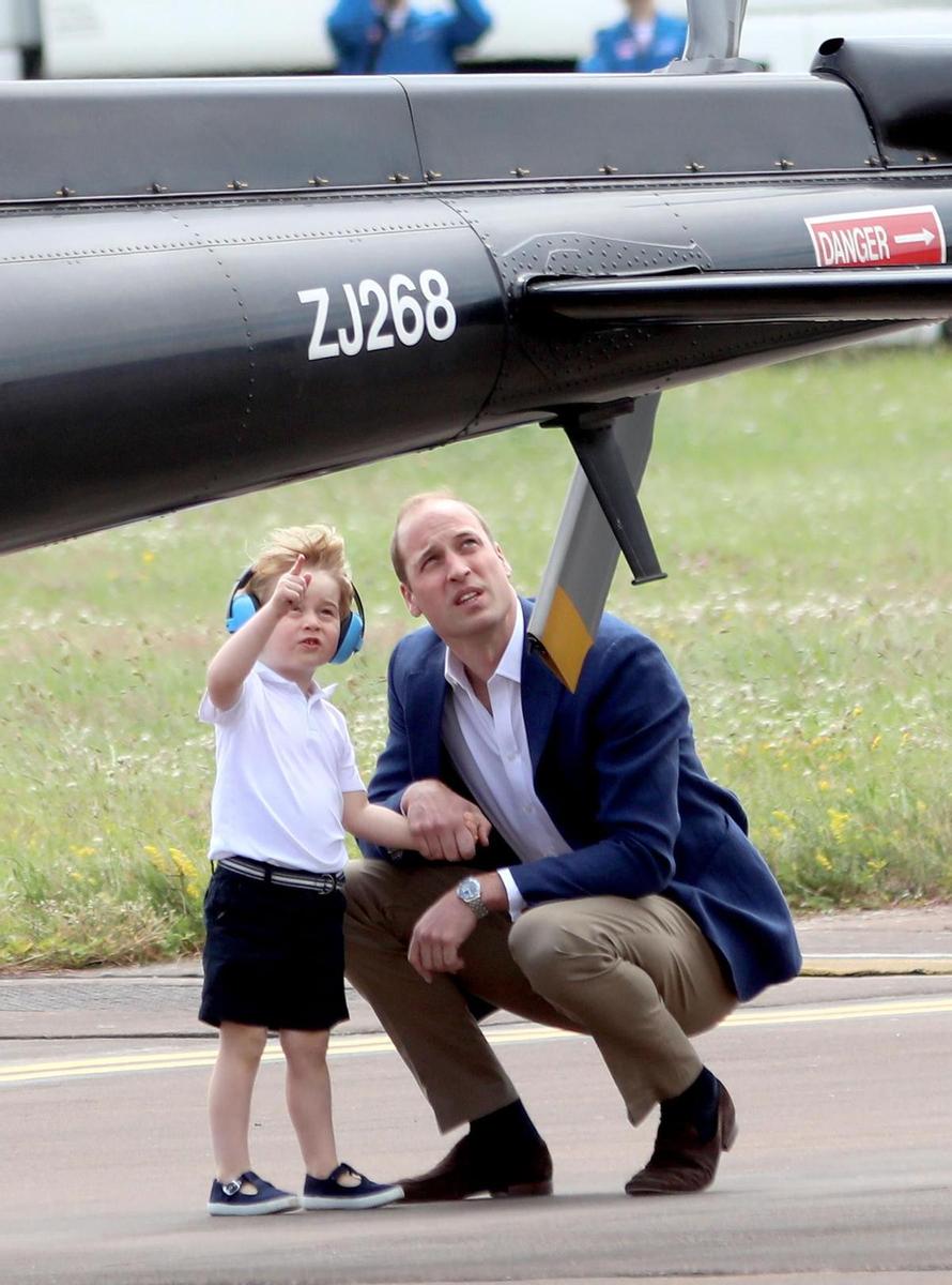 El príncipe George junto a su padre en la base aérea