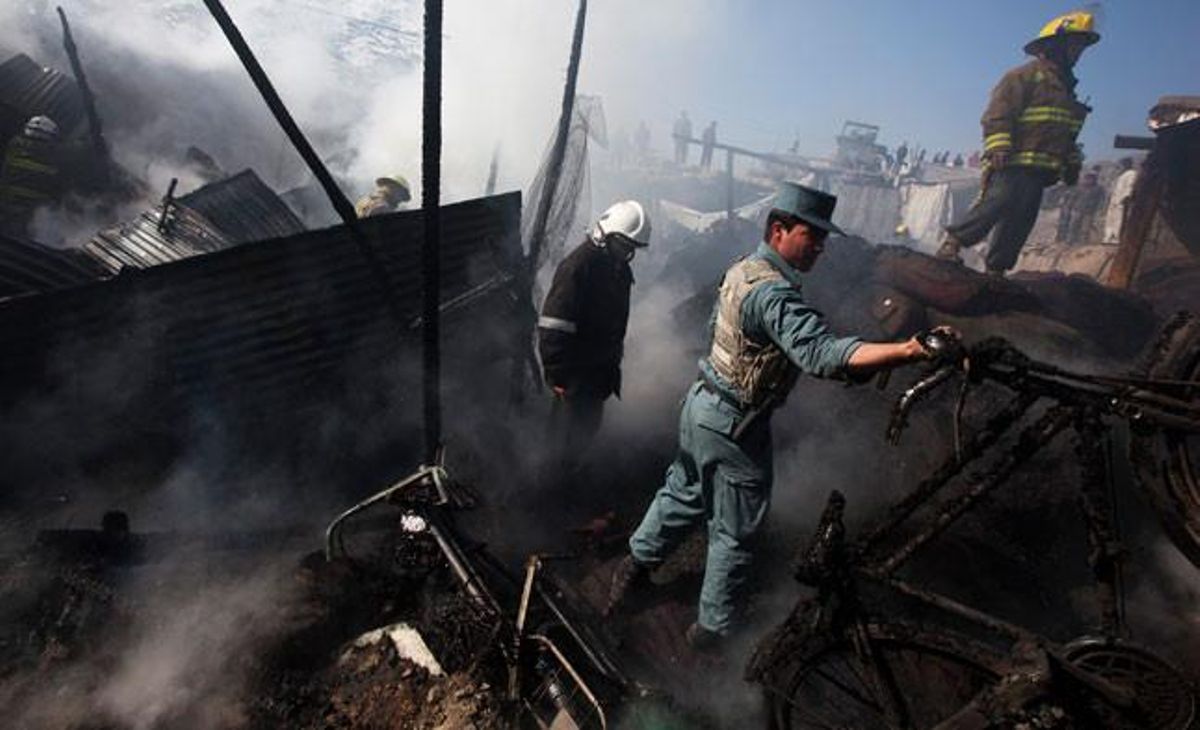 Un policia afganès ajuda els bombers a extingir un incendi en un magatzem de carbó a Kabul. Segons la policia, no hi va haver víctimes registrades i l’incendi va ser accidental.