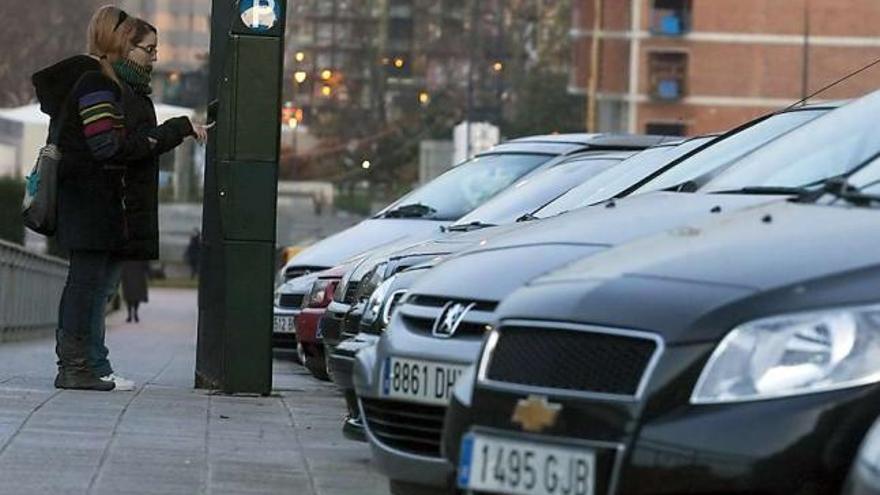 Usuarios del aparcamiento regulado en una calle de Avilés.