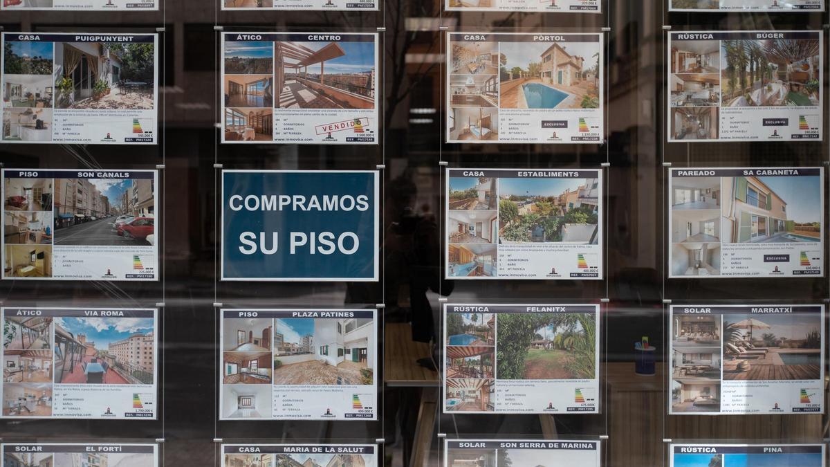 Carteles de viviendas a la venta en el escaparate de una inmobiliaria