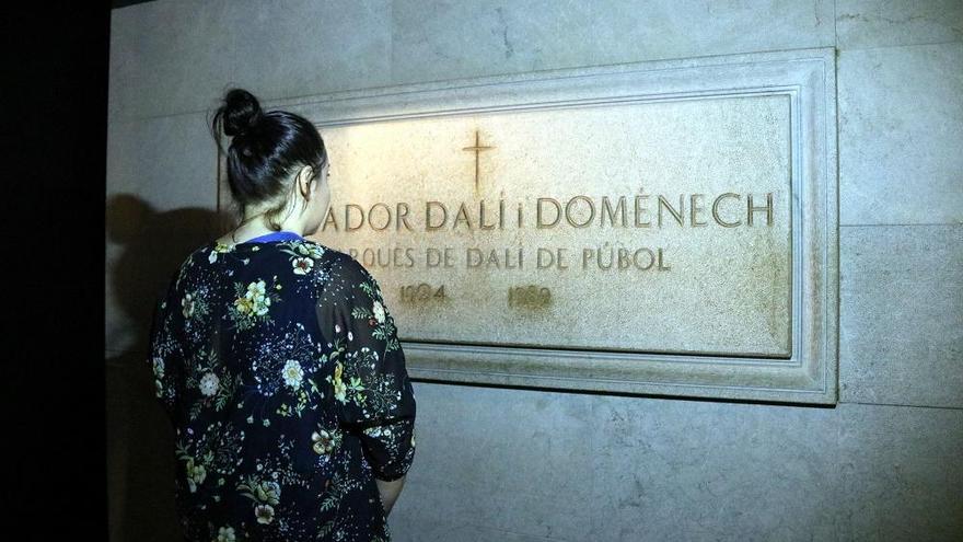 Una persona observant la làpida de Salvador Dalí