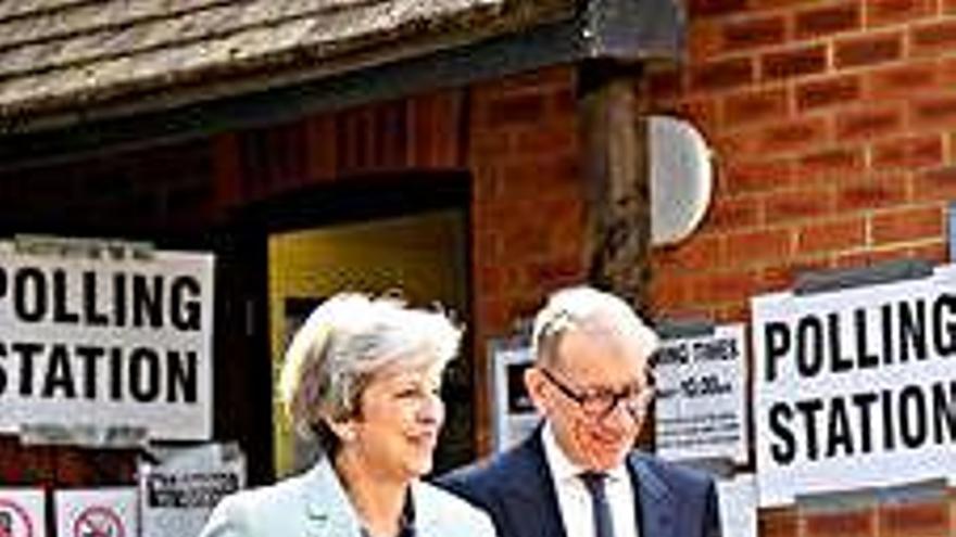 Theresa May i el seu marit surten d&#039;un col·legi electoral després de votar.