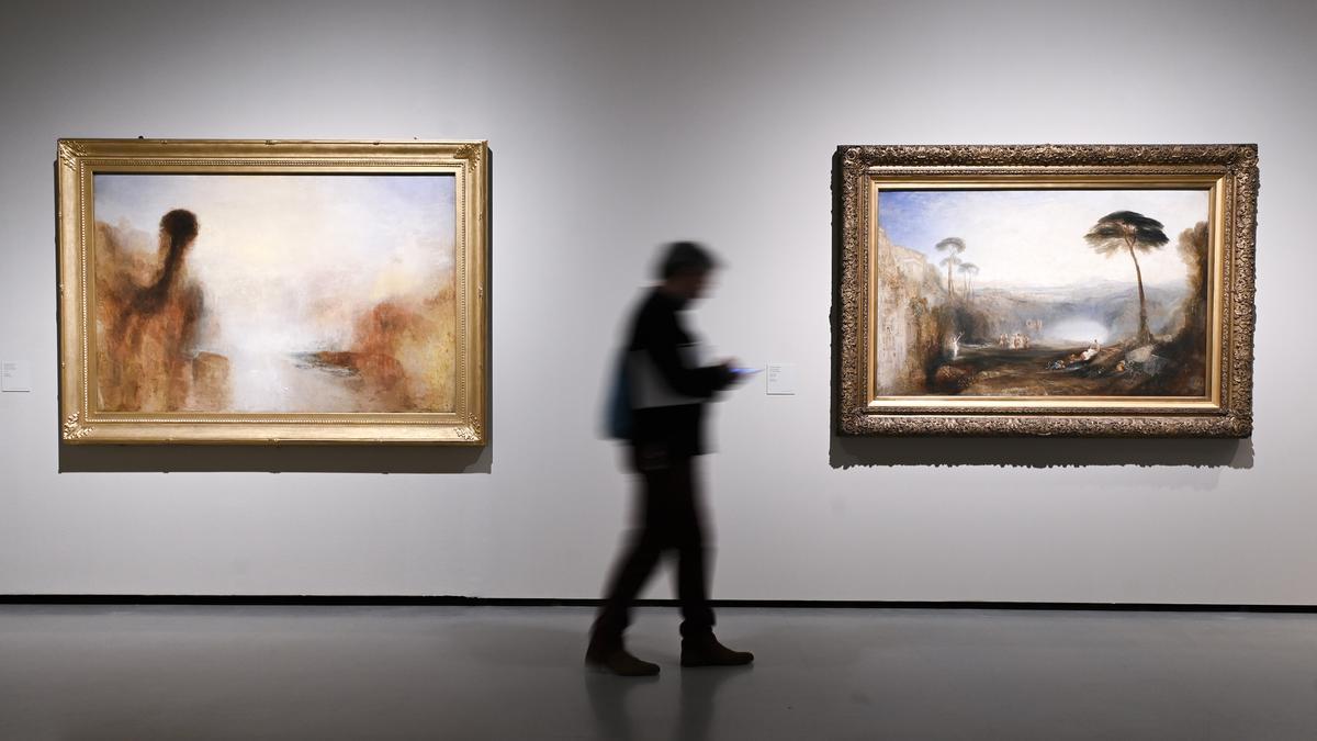 Un visitante, en la muestra sobre Turner del MNAC, entre un esbozo (izquierda) y una obra terminada del pintor inglés.