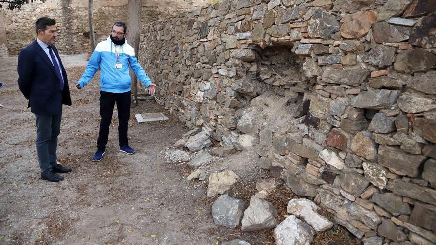 Antonio Alcázar, concejal de Vox, y el guía Miguel Pérez, delante de uno de los desprendimientos en el interior del castillo.